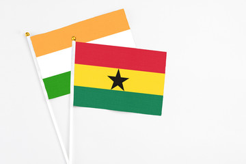 Ghana and India stick flags on white background. High quality fabric, miniature national flag. Peaceful global concept.White floor for copy space.