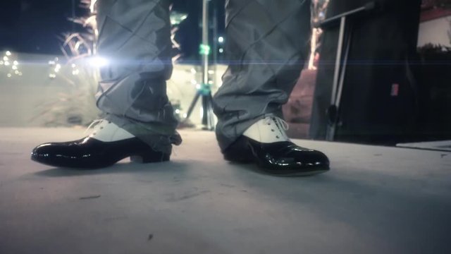 Detail of man dancing on stage with elegant brogue dance shoes. Black and white wingtip derby shoes. 4k