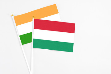Hungary and India stick flags on white background. High quality fabric, miniature national flag. Peaceful global concept.White floor for copy space.