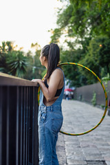 young woman with hula hoop on the street