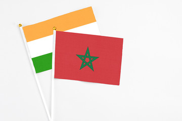 Morocco and India stick flags on white background. High quality fabric, miniature national flag. Peaceful global concept.White floor for copy space.