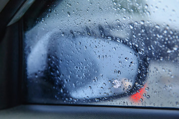 Rainy day on the road, Raindrops on car mirror with side wing mirror