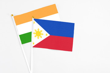 Philippines and India stick flags on white background. High quality fabric, miniature national flag. Peaceful global concept.White floor for copy space.