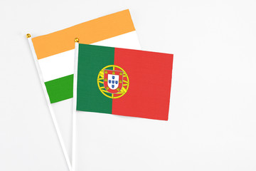 Portugal and India stick flags on white background. High quality fabric, miniature national flag. Peaceful global concept.White floor for copy space.