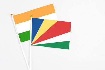 Seychelles and India stick flags on white background. High quality fabric, miniature national flag. Peaceful global concept.White floor for copy space.