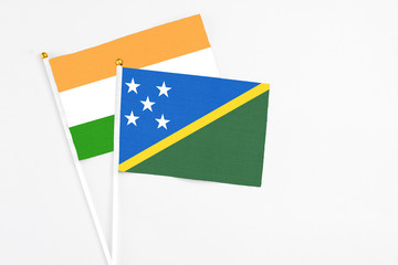 Solomon Islands and India stick flags on white background. High quality fabric, miniature national flag. Peaceful global concept.White floor for copy space.