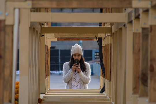 Woman takes a photo through a wooden structure vanishing point effect