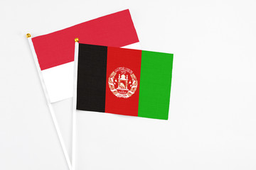 Afghanistan and Indonesia stick flags on white background. High quality fabric, miniature national flag. Peaceful global concept.White floor for copy space.