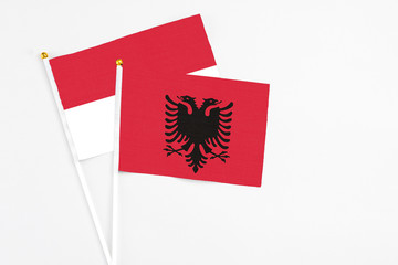 Obraz premium Albania and Indonesia stick flags on white background. High quality fabric, miniature national flag. Peaceful global concept.White floor for copy space.