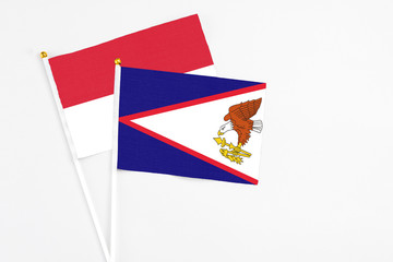 American Samoa and Indonesia stick flags on white background. High quality fabric, miniature national flag. Peaceful global concept.White floor for copy space.