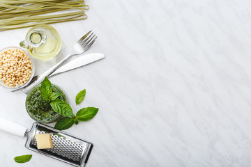 Raw green fettuccine and Pesto sauce with ingredients: pine nuts, basil, olive oil, parmesan and...