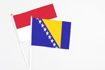 Bosnia Herzegovina and Indonesia stick flags on white background. High quality fabric, miniature national flag. Peaceful global concept.White floor for copy space.