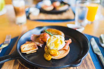Breakfast set with egg benedict sausage in hot pan