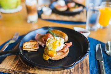 Breakfast set with egg benedict sausage in hot pan
