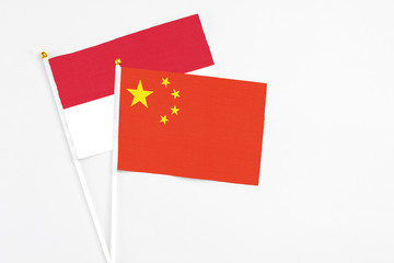 China and Indonesia stick flags on white background. High quality fabric, miniature national flag. Peaceful global concept.White floor for copy space.