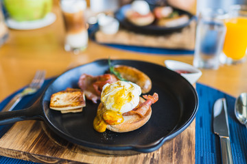 Breakfast set with egg benedict sausage in hot pan