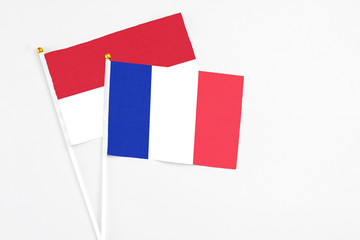 France and Indonesia stick flags on white background. High quality fabric, miniature national flag. Peaceful global concept.White floor for copy space.