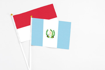 Guatemala and Indonesia stick flags on white background. High quality fabric, miniature national flag. Peaceful global concept.White floor for copy space.