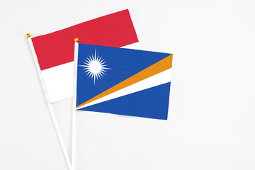 Marshall Islands and Indonesia stick flags on white background. High quality fabric, miniature national flag. Peaceful global concept.White floor for copy space.