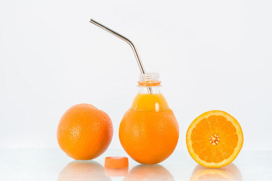 Concept image for no unnecessary packaging and environmental consciousness showing fresh oranges and a reusable stainless steel drinking straw.  
