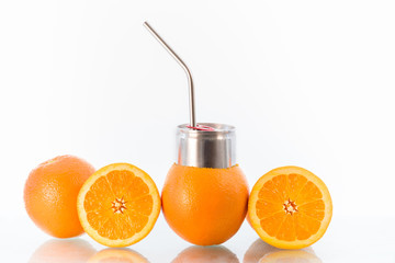 Concept image for no unnecessary packaging and environmental consciousness showing fresh oranges and a reusable stainless steel drinking straw.  