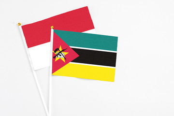 Mozambique and Indonesia stick flags on white background. High quality fabric, miniature national flag. Peaceful global concept.White floor for copy space.