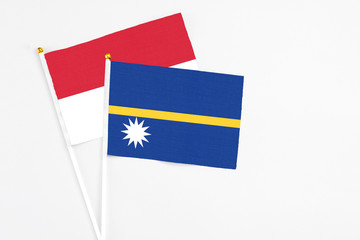 Nauru and Indonesia stick flags on white background. High quality fabric, miniature national flag. Peaceful global concept.White floor for copy space.