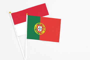 Portugal and Indonesia stick flags on white background. High quality fabric, miniature national flag. Peaceful global concept.White floor for copy space.