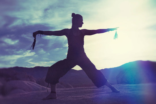 Shamanic Movement Woman on Big Boulders desert twilight qi gong.  Shamanic Tai Chi