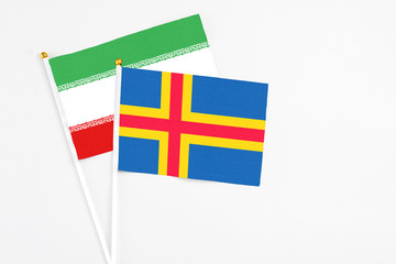 Aland Islands and Iran stick flags on white background. High quality fabric, miniature national...