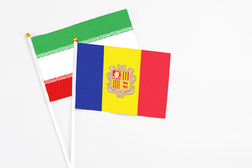 Andorra and Iran stick flags on white background. High quality fabric, miniature national flag. Peaceful global concept.White floor for copy space.