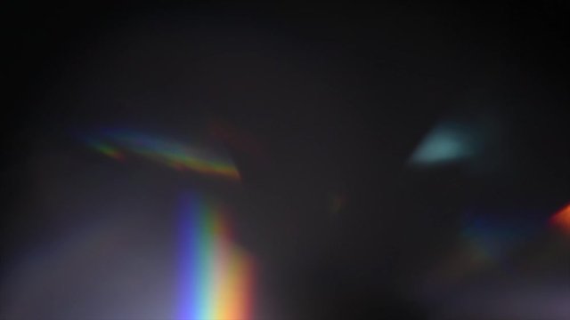 Lens Flare, Abstract Bokeh Lights Moving. Leaking Reflection of a Glass, Crystal, Defocused Shining Colorful rainbow Light Leaks, Rays on Black Background. 4K UHD video, slow motion