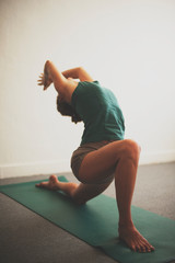 Woman in lunging yoga back bend. Artfully color processed photo. 