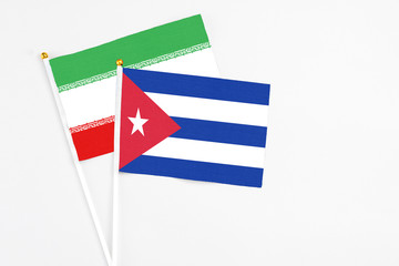 Cuba and Iran stick flags on white background. High quality fabric, miniature national flag. Peaceful global concept.White floor for copy space.