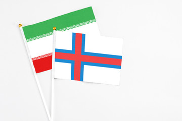 Faroe Islands and Iran stick flags on white background. High quality fabric, miniature national flag. Peaceful global concept.White floor for copy space.