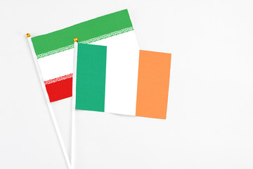 Ireland and Iran stick flags on white background. High quality fabric, miniature national flag. Peaceful global concept.White floor for copy space.