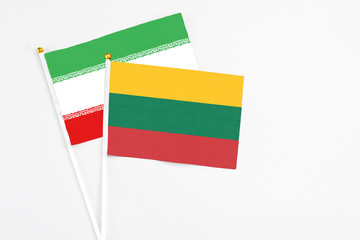 Lithuania and Iran stick flags on white background. High quality fabric, miniature national flag. Peaceful global concept.White floor for copy space.