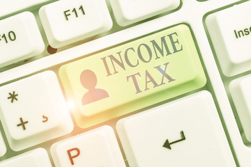 Writing note showing Income Tax. Business concept for Annual charge levied on both earned and unearned income