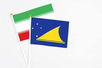 Tokelau and Iran stick flags on white background. High quality fabric, miniature national flag. Peaceful global concept.White floor for copy space.