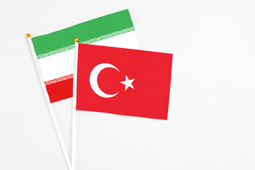 Turkey and Iran stick flags on white background. High quality fabric, miniature national flag. Peaceful global concept.White floor for copy space.