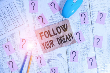 Text sign showing Follow Your Dream. Business photo showcasing Keep track on your goals Live the life you want to be Writing tools, computer stuff and scribbled paper on top of wooden table