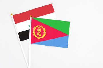 Eritrea and Iraq stick flags on white background. High quality fabric, miniature national flag. Peaceful global concept.White floor for copy space.