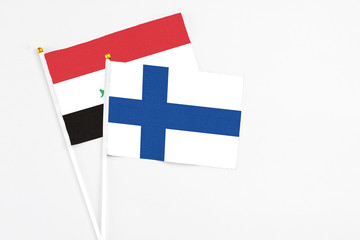 Finland and Iraq stick flags on white background. High quality fabric, miniature national flag. Peaceful global concept.White floor for copy space.