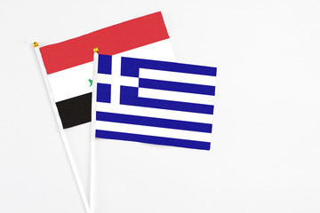 Obraz premium Greece and Iraq stick flags on white background. High quality fabric, miniature national flag. Peaceful global concept.White floor for copy space.
