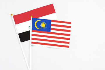 Malaysia and Iraq stick flags on white background. High quality fabric, miniature national flag. Peaceful global concept.White floor for copy space.