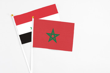 Morocco and Iraq stick flags on white background. High quality fabric, miniature national flag. Peaceful global concept.White floor for copy space.