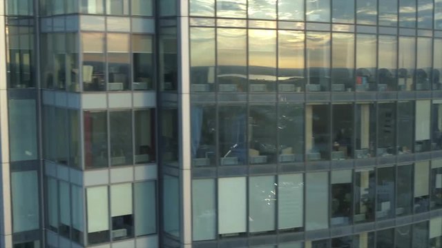 Aerial view of large russian city, buildings, trees and modern glass skyscraper in summer morning against blue coudy sky. Stock footage. Beautiful urban landscape