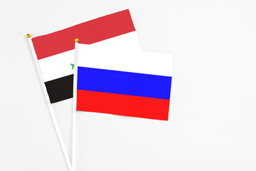 Russia and Iraq stick flags on white background. High quality fabric, miniature national flag. Peaceful global concept.White floor for copy space.