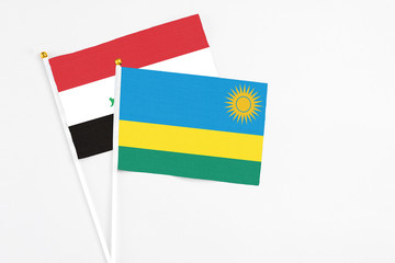 Rwanda and Iraq stick flags on white background. High quality fabric, miniature national flag. Peaceful global concept.White floor for copy space.