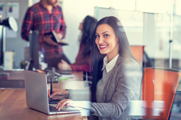 Creative young woman working in office with graphic tablet